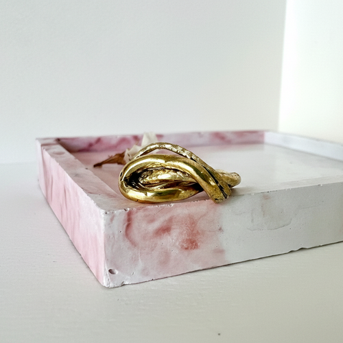 Anello editoriale su vassoio in cemento rosa