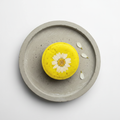 Shampoo bar giallo vista dall'alto su vassoio cemento